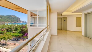 A modern hotel room with a balcony overlooking a scenic coastal area, including a view of the sea and mountains. - Hatipoglu Beach Hotel (Alanya)