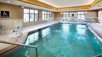 Una piscina techada, sillones reclinables de piscina