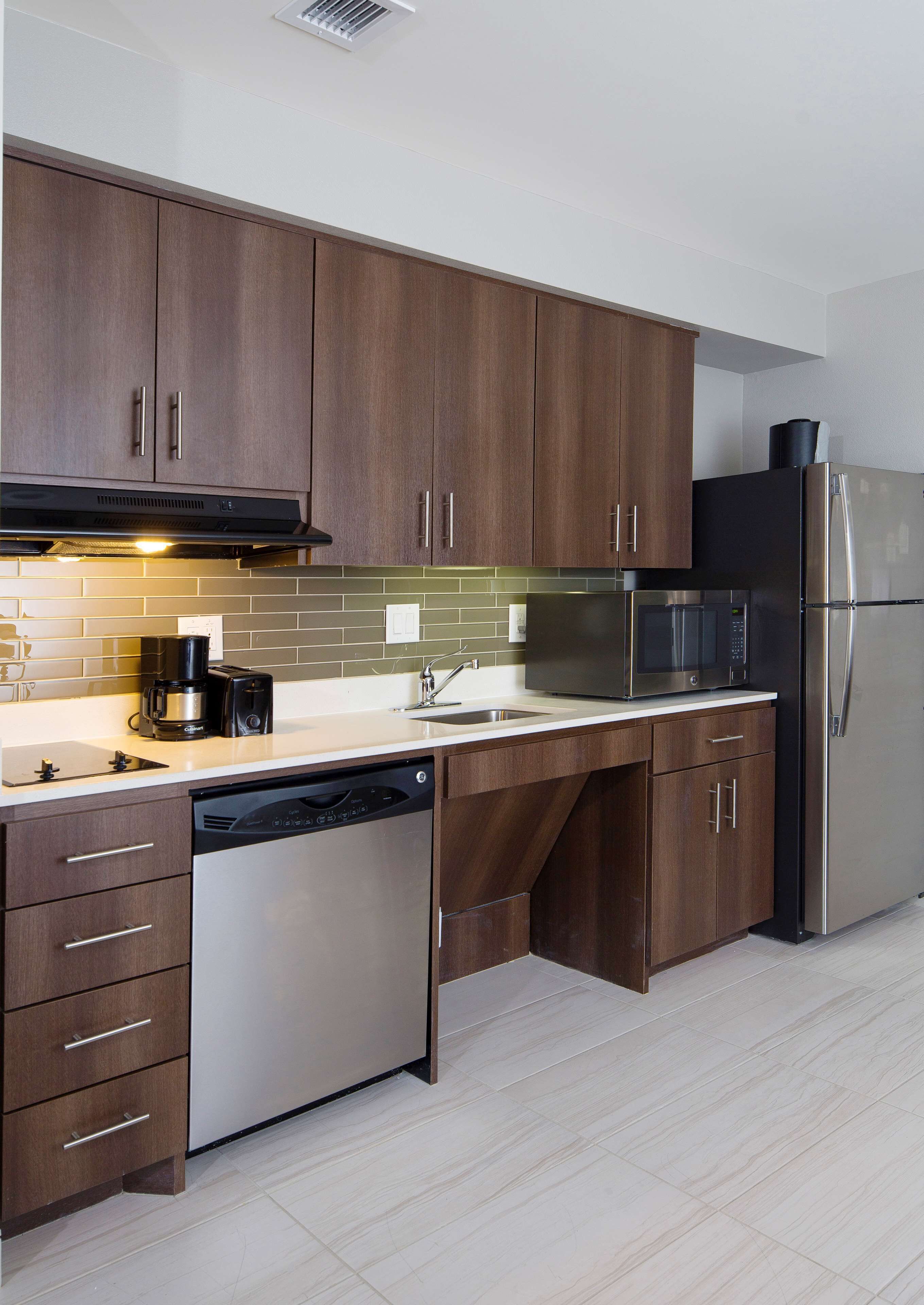 Une cuisine moderne avec des meubles en bois, des appareils en acier inoxydable et un lave-vaisselle.