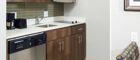 A modern kitchen with wooden cabinets, a stainless steel dishwasher, a microwave, and a sink.