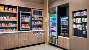 A snack and beverage vending area with various snack options and a refrigerated beverage dispenser. - SpringHill Suites by Marriott Milwaukee Downtown (Milwaukee)