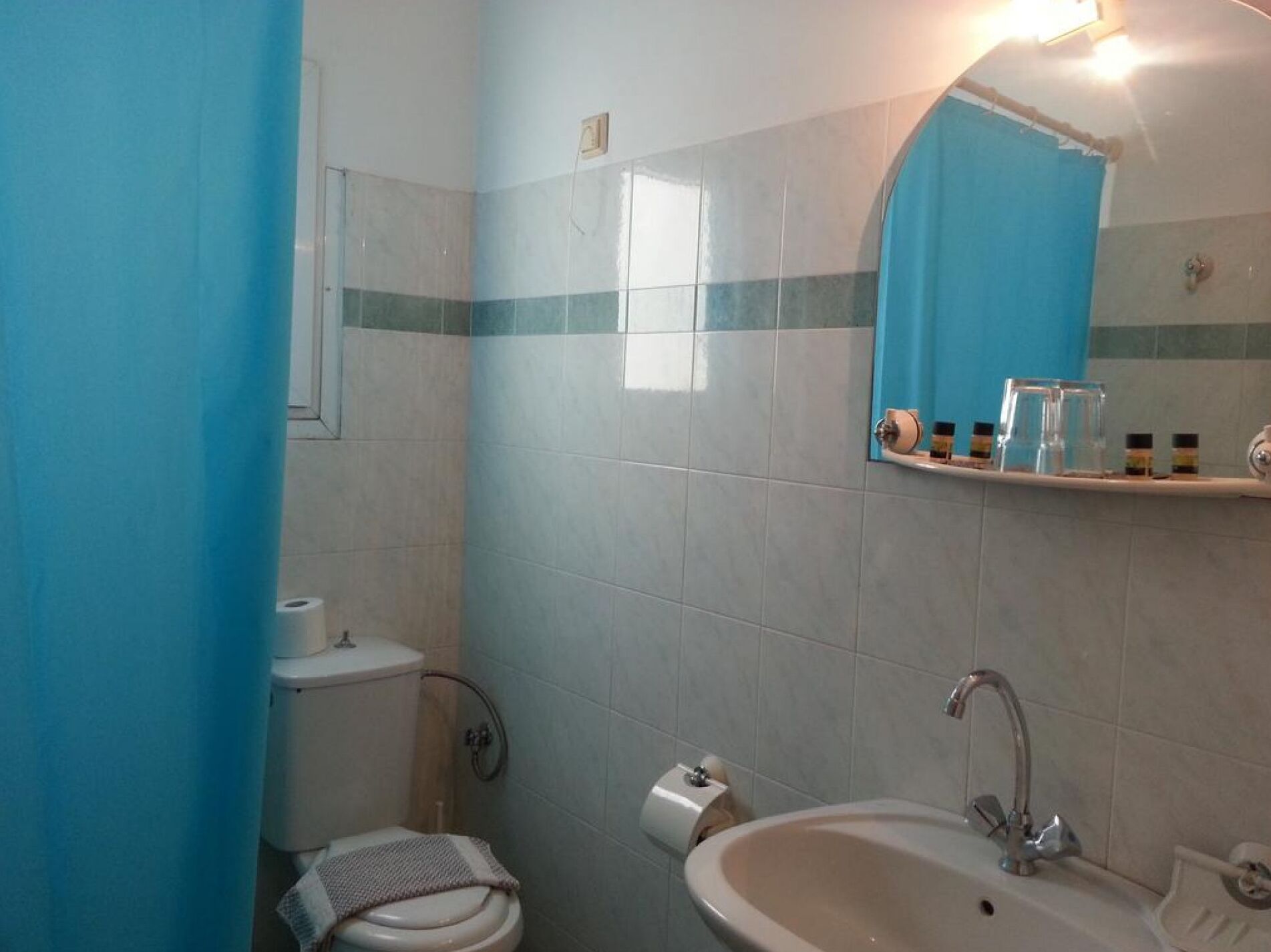 A bathroom with a toilet, sink, and shower area.