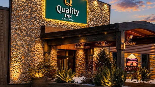 A hotel with a stone facade, a sign for 'Quality Inn by Choice Hotels,' and a 'Copper Lounge' sign.