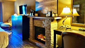A cozy room with a fireplace, a television, and a lamp. - Quality Inn Fort Frances (Fort Frances)