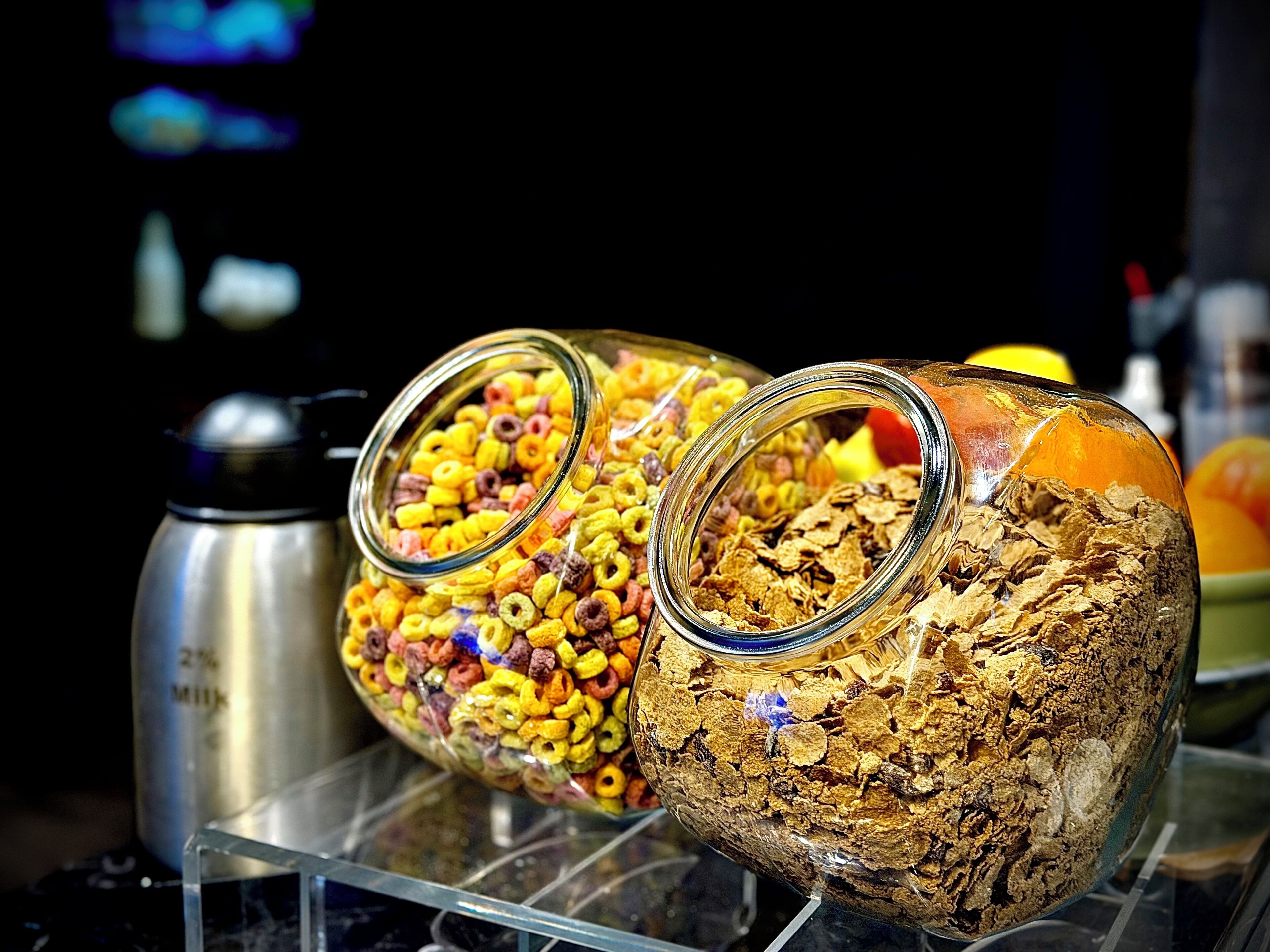 Two glass jars filled with cereal on a display shelf.