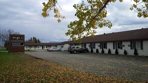 A motel with a signboard, a parking lot, and a building with multiple windows. - The Walla Walla Inn (Rainy River)