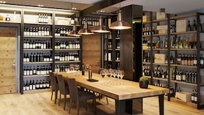 A modern wine cellar with wooden shelves and a long table for tasting. - Arborina Relais (La Morra)