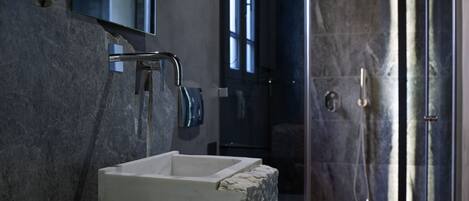 Une salle de bain moderne avec un lavabo en marbre, une douchette à main et des toilettes.
