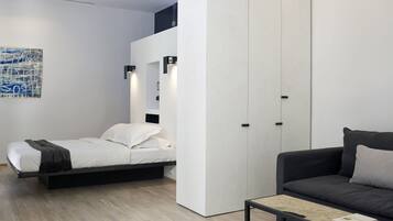 A modern bedroom with a bed, a sofa, and a coffee table.