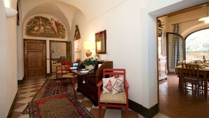 Un comedor con piso a cuadros, muebles de madera y un cuadro grande en la pared.