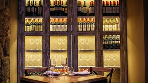 Un ristorante con una vetrina per vini e un tavolo apparecchiato per due persone.