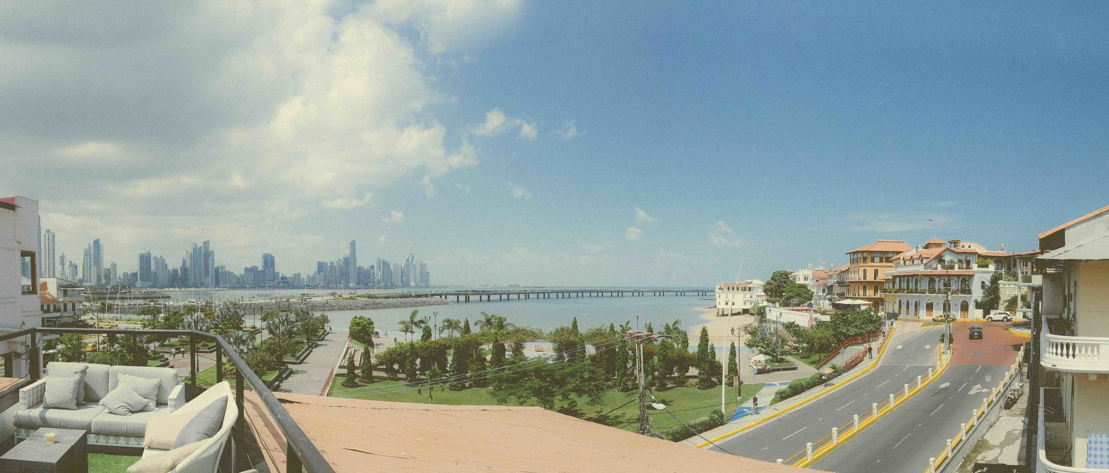 A balcony with a view of a city skyline, a bridge, and a marina.