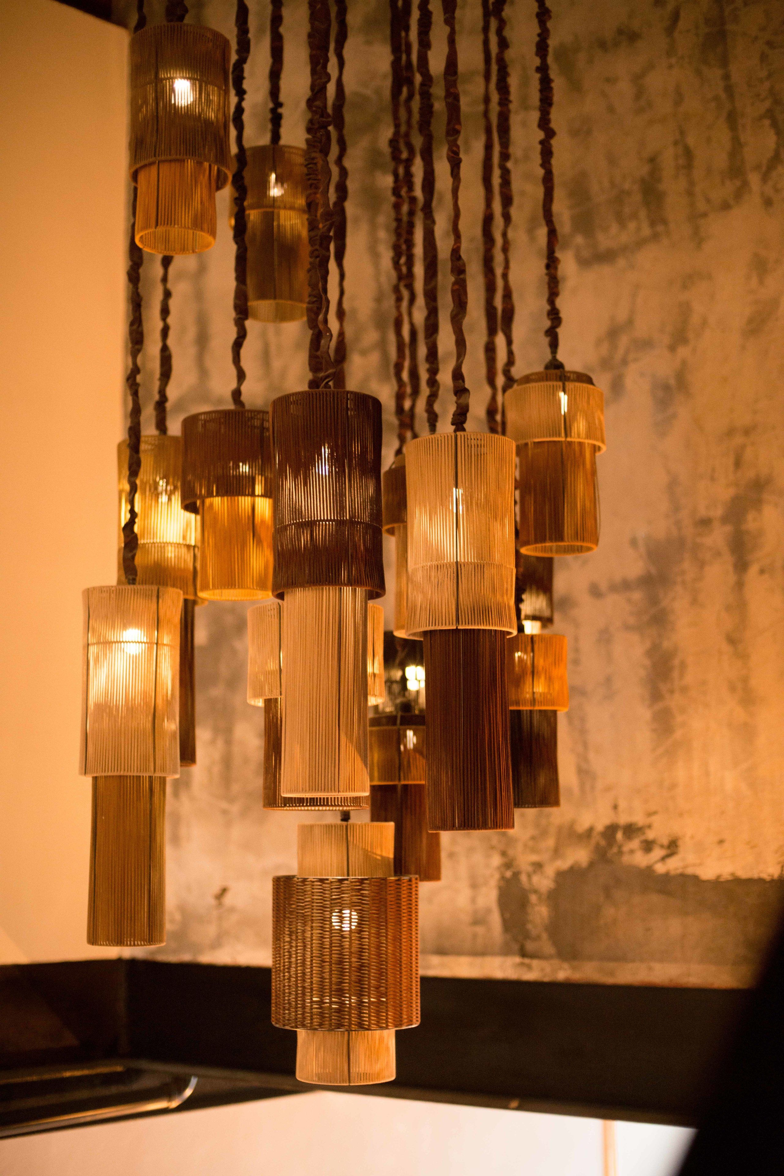 Un lampadario moderno con diverse lampade cilindriche pendenti dal soffitto.