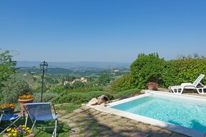 A pool with a clear view of the countryside, surrounded by greenery and a chair. - Torre Tavarnelle (Barberino Tavarnelle)