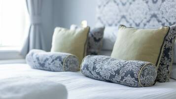 A neatly made bed with patterned pillows and a matching headboard.
