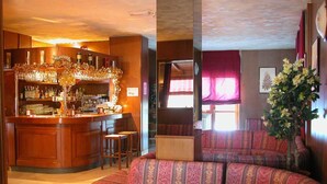 Un espace bar avec un comptoir et des tabourets en bois, un coin salon avec des canapés à motifs et une grande plante.