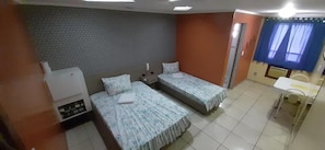 A room with two beds, a small table, and a chair. - Charlott Hotel (São Paulo)