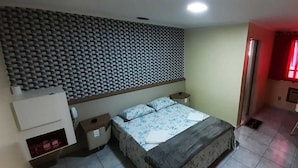 A bedroom with a bed, bedside tables, a desk, and a chair. - Charlott Hotel (São Paulo)