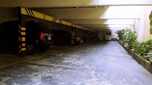 A parking garage with multiple cars parked under a covered area. - Charlott Hotel (São Paulo)