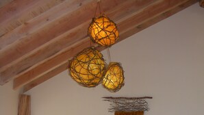 Una sala de estar acogedora con techo de madera, un sofá con cojines, una mesita de centro y vistas al exterior.