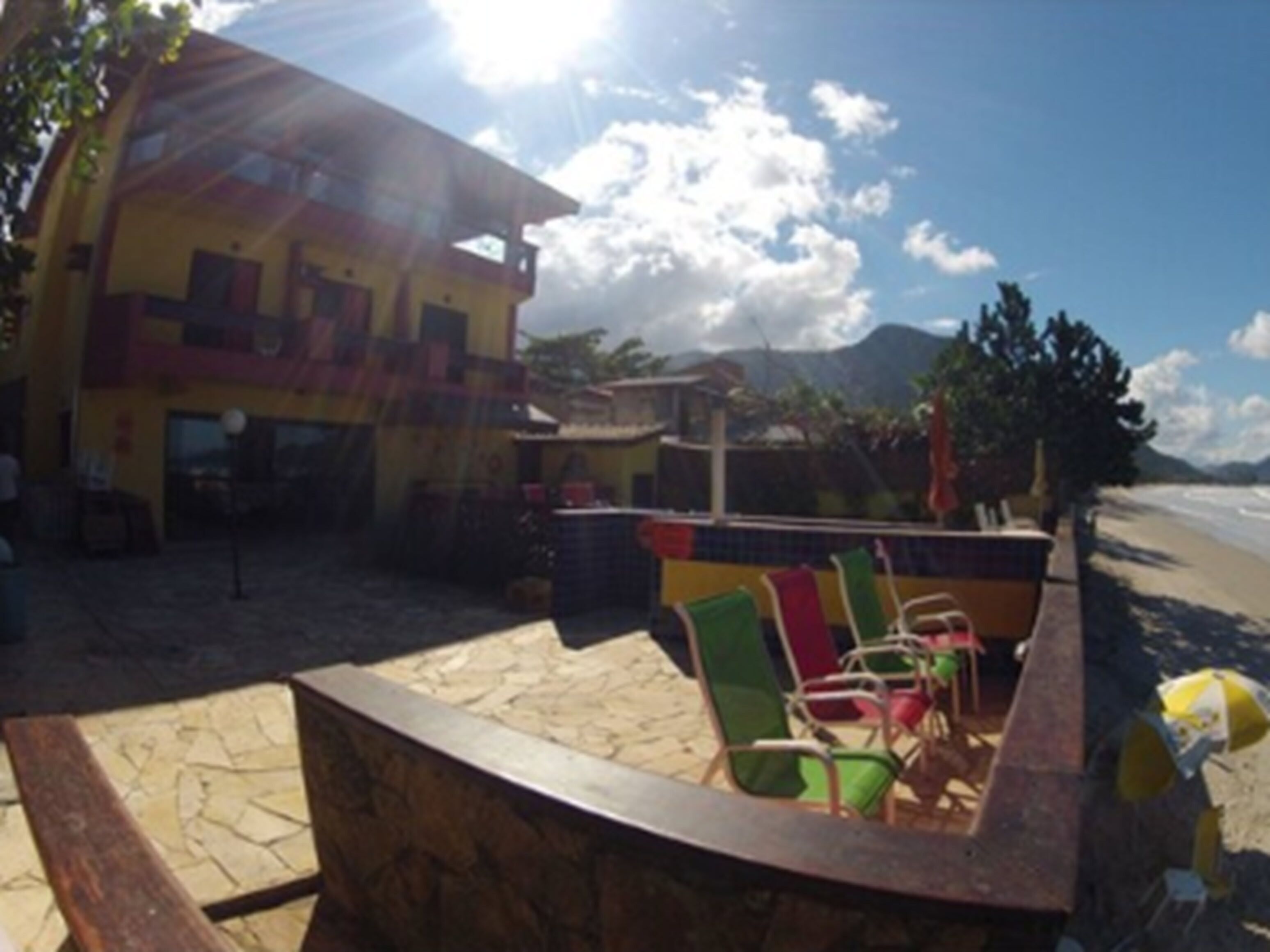 A beachside building with a patio area featuring outdoor seating.
