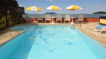 Una piscina al aire libre, tumbonas
