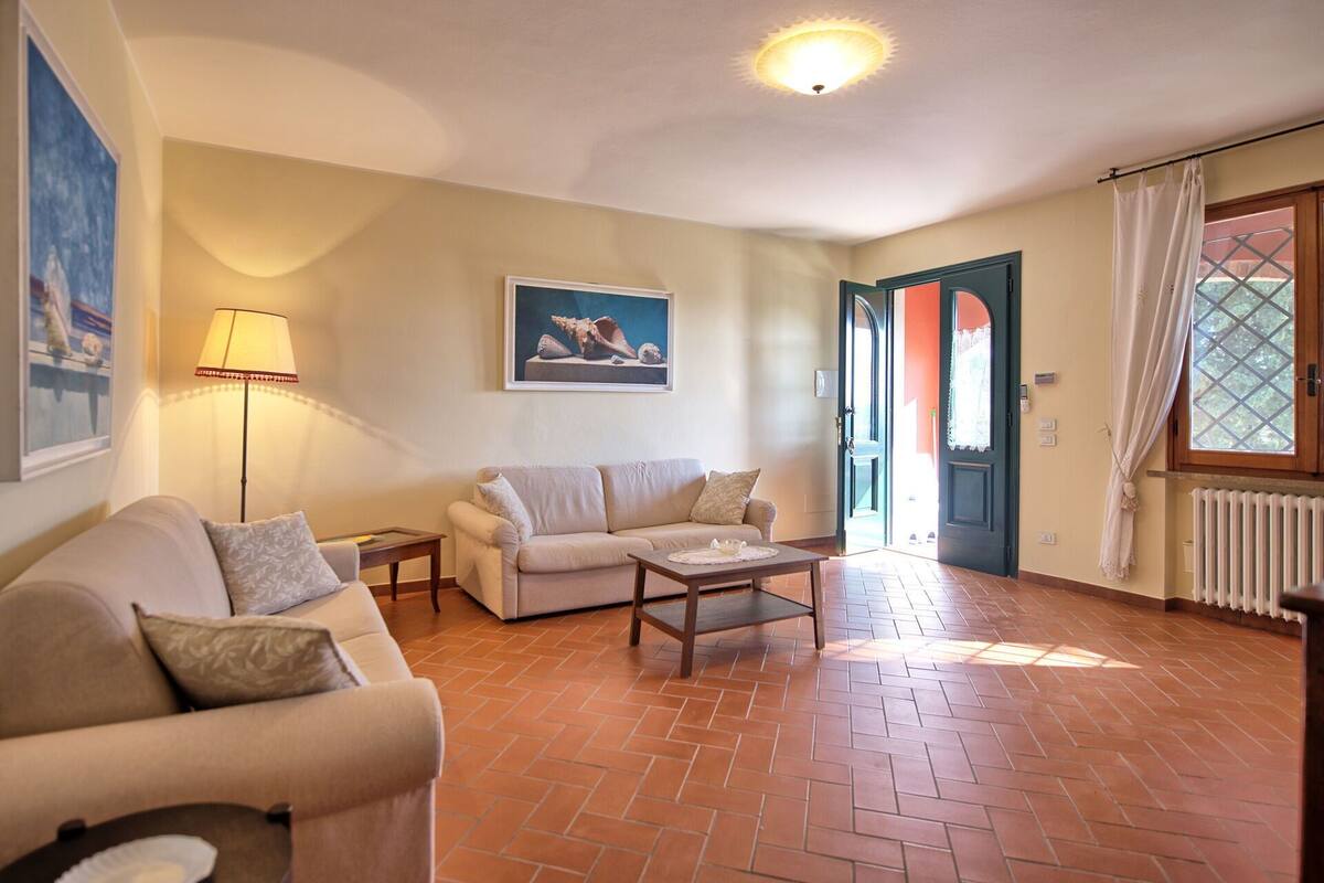 A living room with a sofa, a coffee table, a lamp, and a painting on the wall.