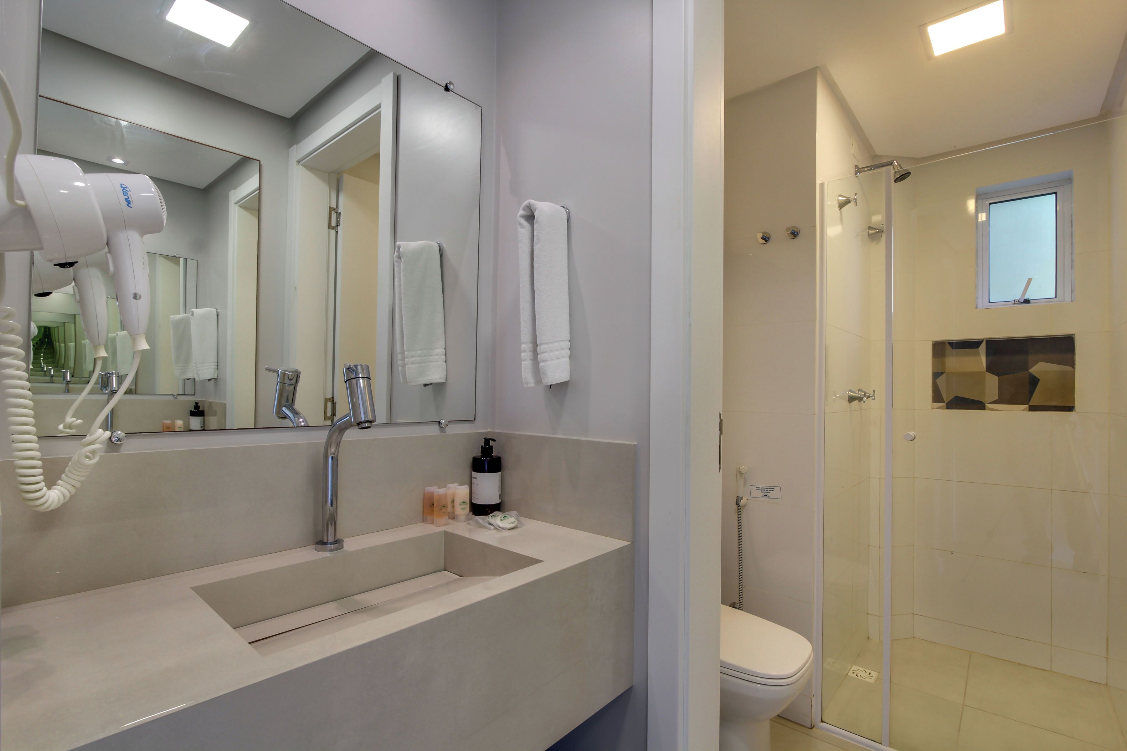 Une salle de bain moderne avec un lavabo, un miroir et une douche à parois de verre.