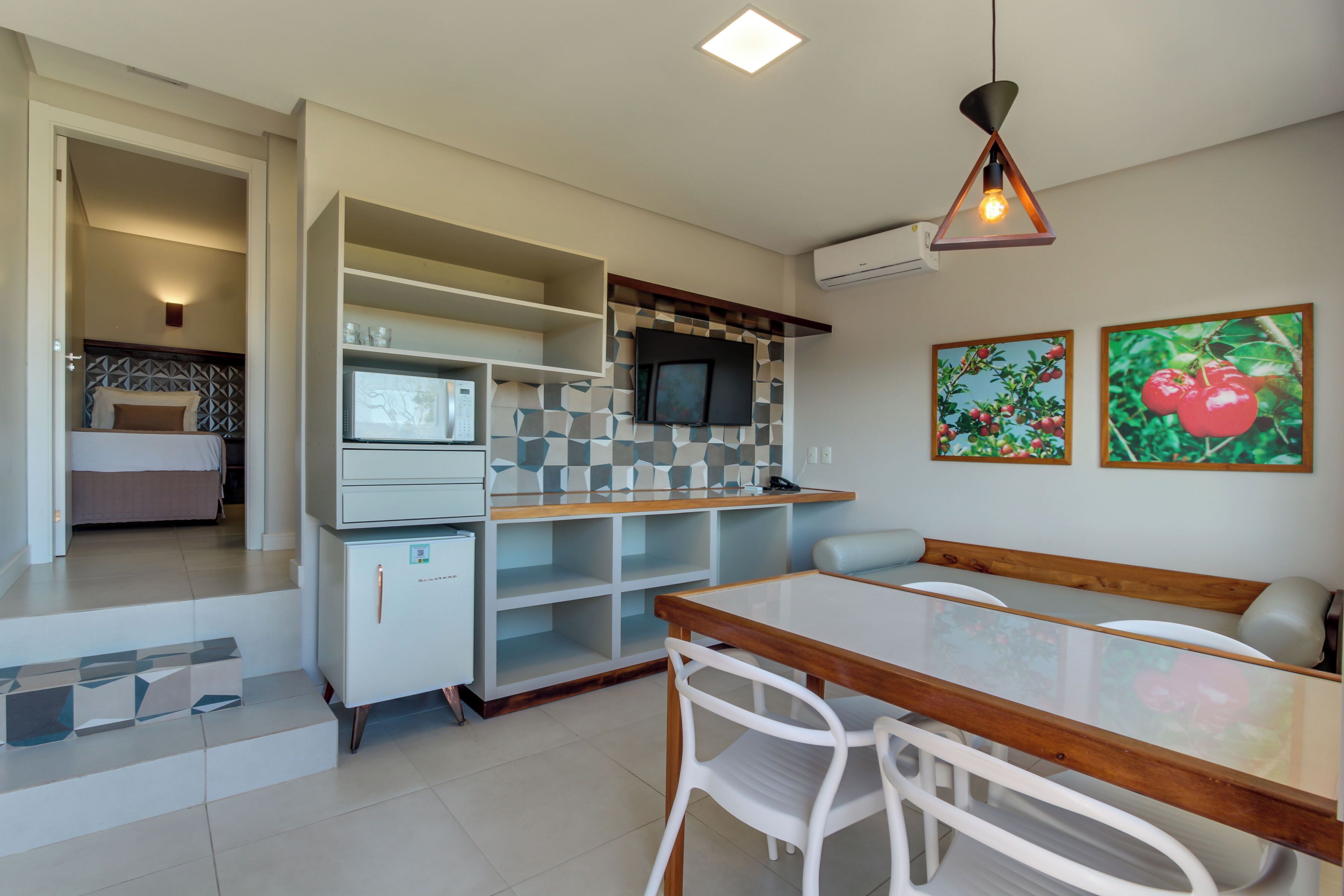Un espacio habitable compacto con kitchenette, comedor y dormitorio.