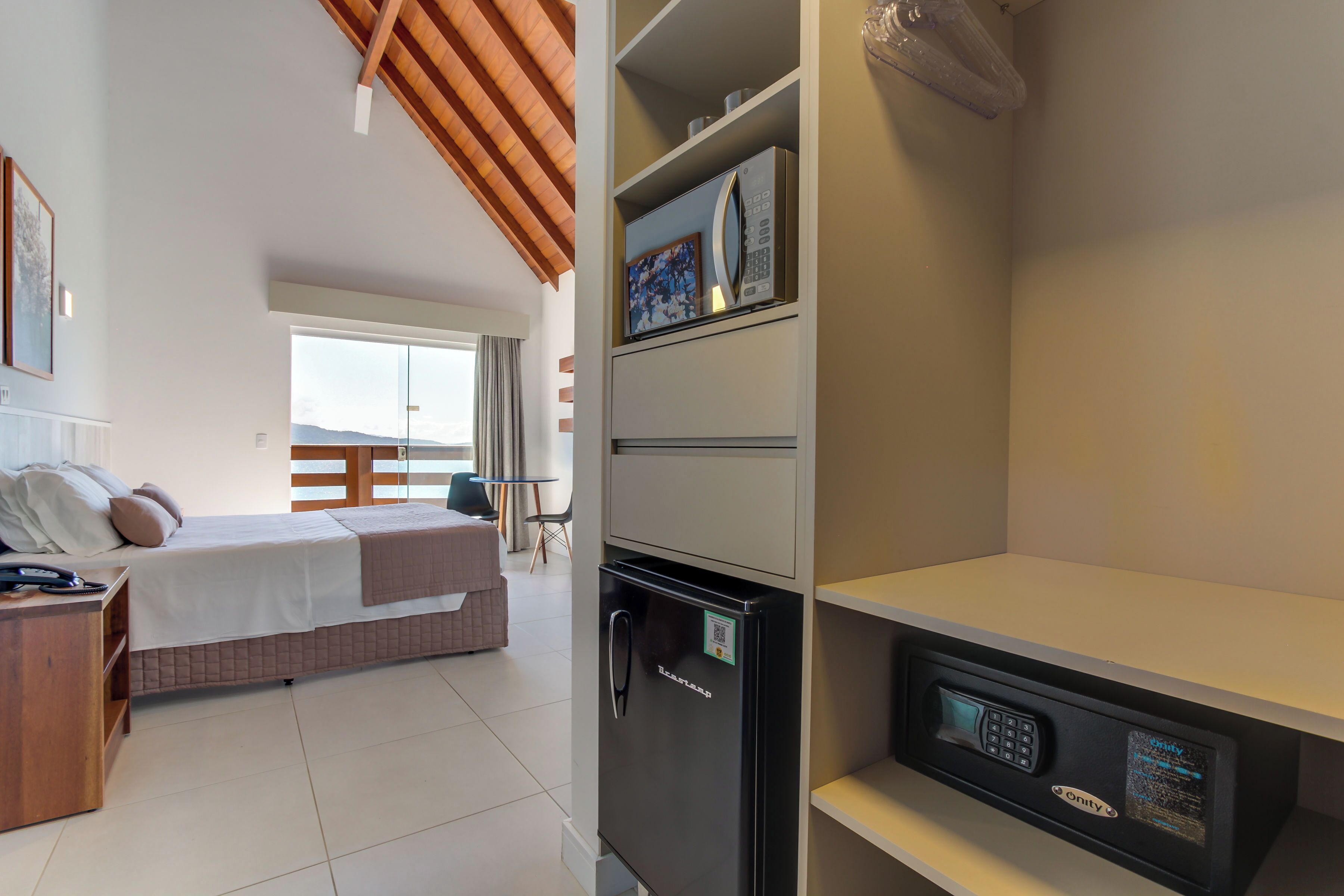 Une chambre d’hôtel équipée d’un lit, d’un bureau, d’un réfrigérateur et d’un four à micro-ondes.