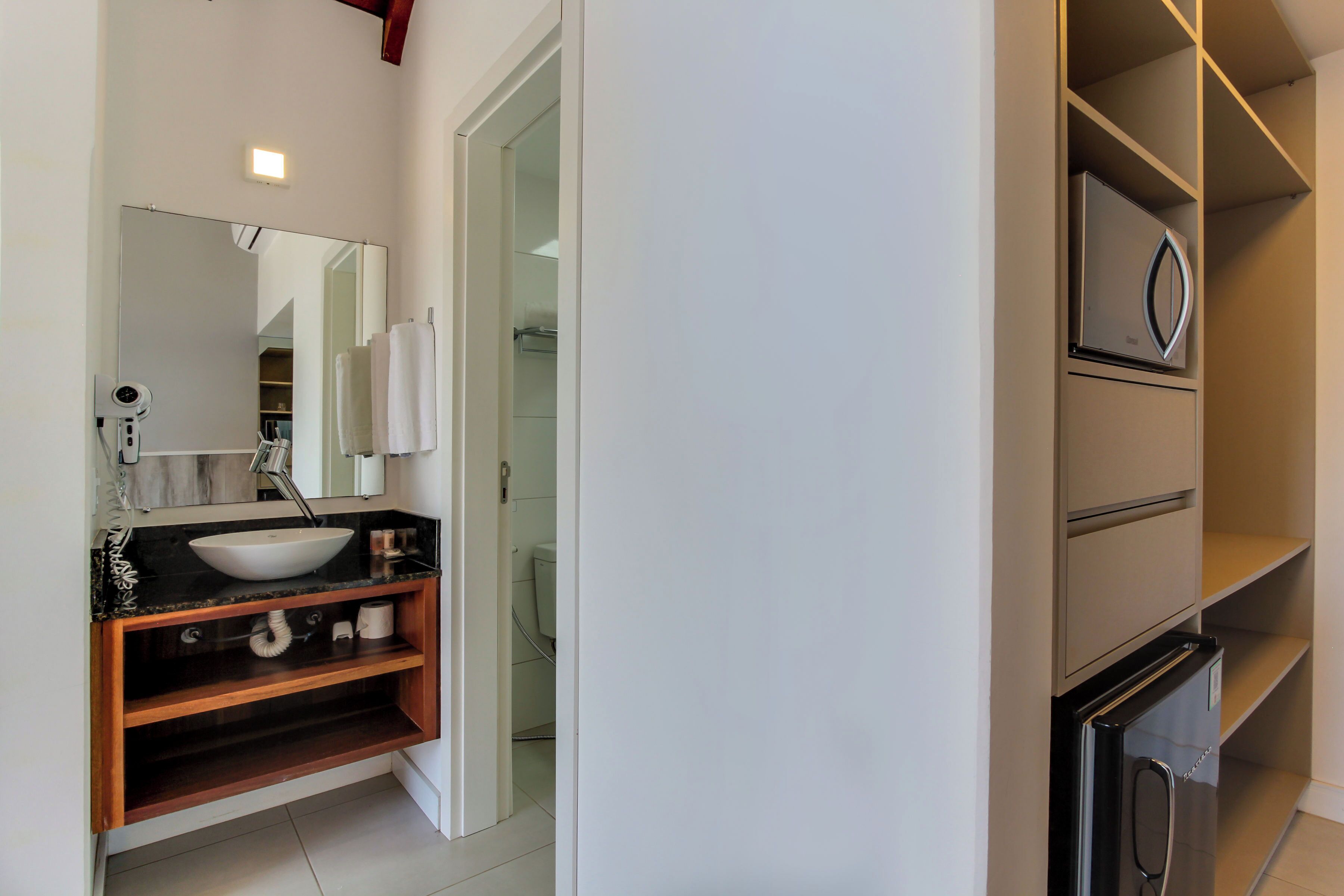 A modern bathroom with a freestanding sink, a mirror, and a built-in cabinet.