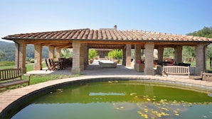 Un área de estar al aire libre con techo y piscina.
