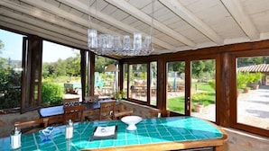 Una cocina con encimera de azulejos verdes, armarios de madera y vistas al patio exterior.