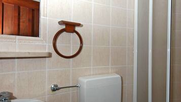 A bathroom with a white sink, toilet, and shower.