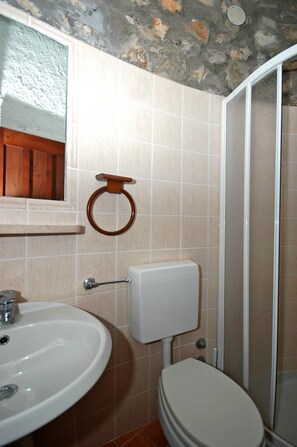 A bathroom with a white sink, toilet, and shower.