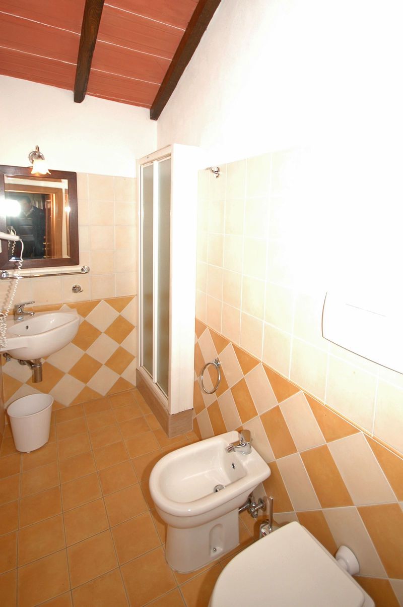 Une salle de bain équipée d’un lavabo, d’un bidet, de toilettes et d’un espace douche.