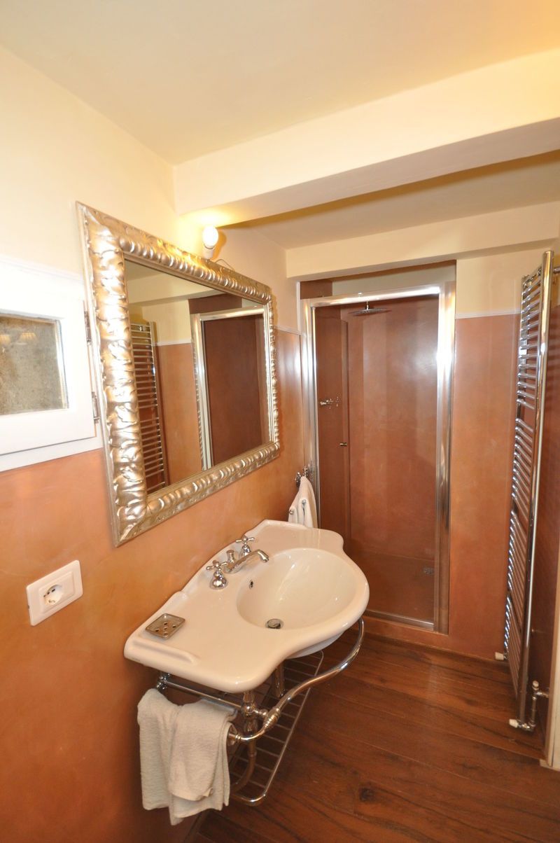 A bathroom with a white sink, a large mirror, and a wooden door.