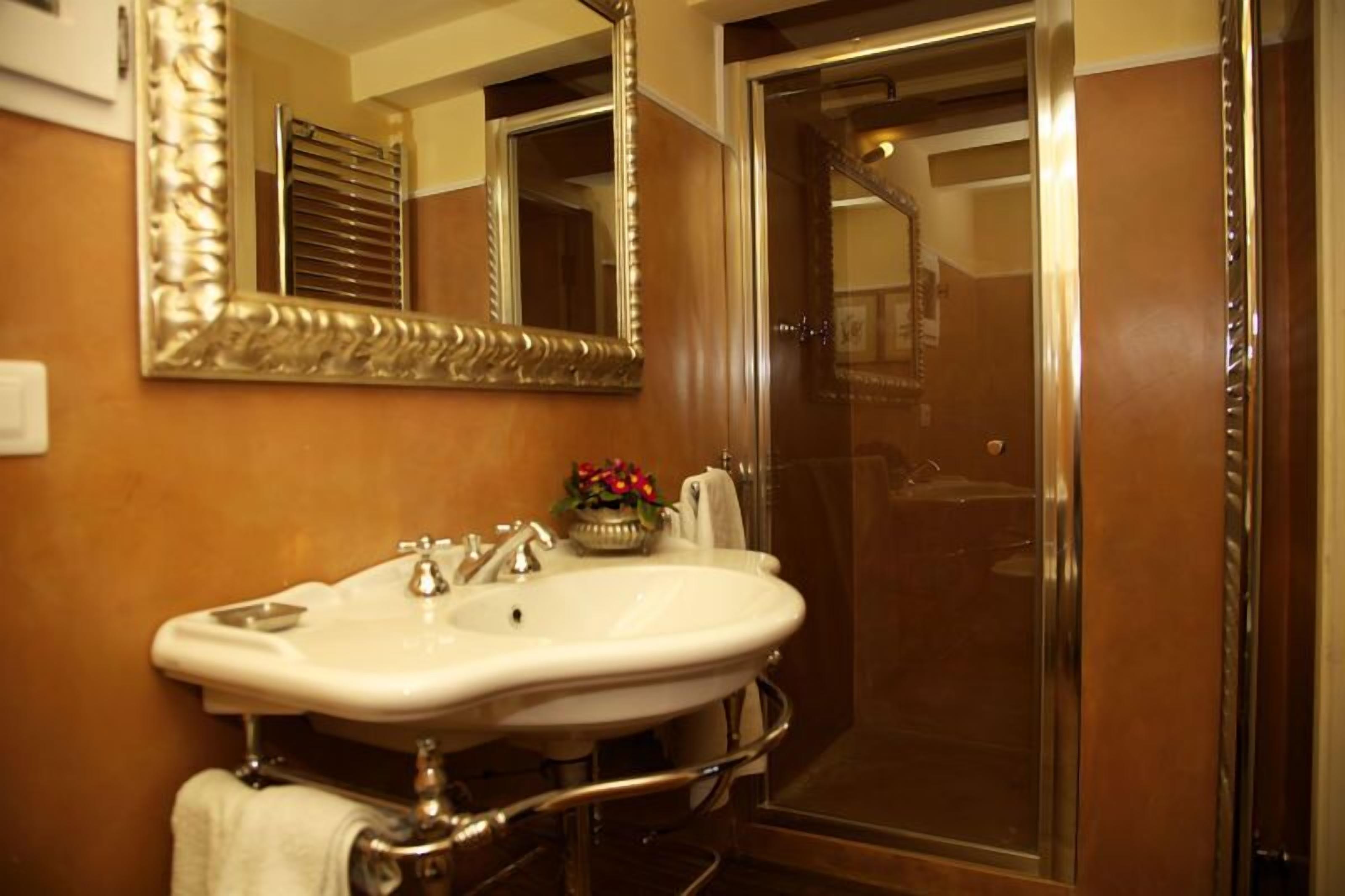 A bathroom with a white sink, a large mirror, and a shower area.