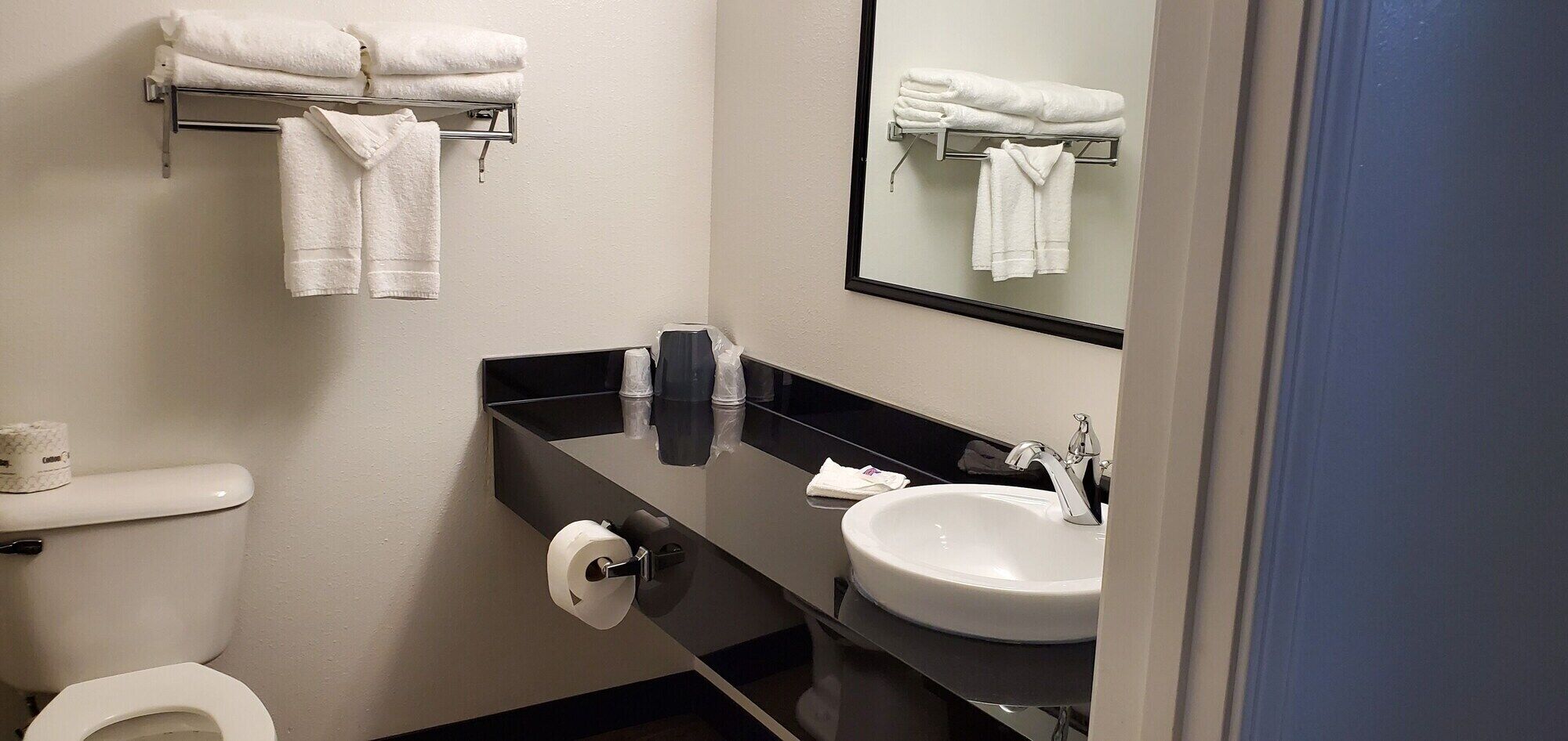 A modern bathroom with a toilet, sink, and towel rack.