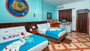 A hotel room with two beds, a desk, a computer, and a large painting on the wall. - Hotel Coloma Galapagos (Puerto Ayora)