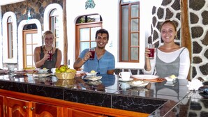 A kitchen with a marble countertop, wooden cabinets, and a stone wall. - Hotel Coloma Galapagos (Puerto Ayora)
