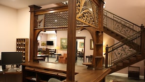 A spacious room with a wooden staircase, a desk with a computer, and a large mirror reflecting the room. - Hearthstone Elegant Lodge by the River (Kamiah)
