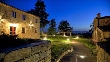 Un edificio de piedra con un camino pavimentado que conduce a un espacio al aire libre cubierto.