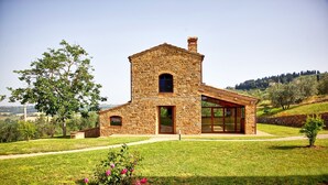 A stone house with a large window and a covered porch. - Villa Ferdinando (Poggibonsi)