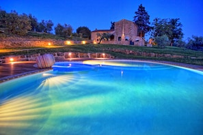 A swimming pool with a stone building in the background.