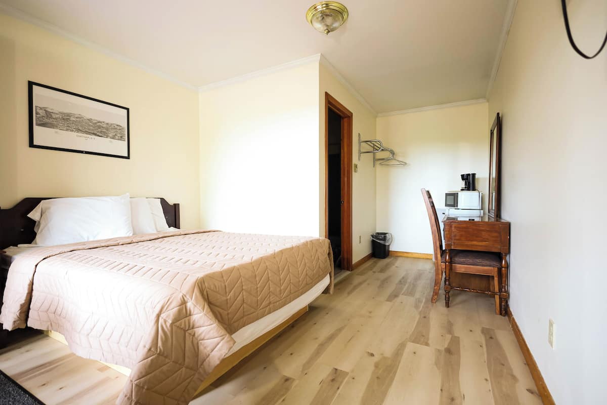 Ein Schlafzimmer mit einem Bett, einem Schreibtisch und einem Stuhl.