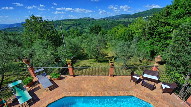 A swimming pool with a patio area, surrounded by lush greenery and hills in the background. - Casa Vania (Reggello)