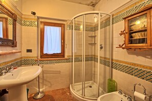 Une salle de bain avec une douche à parois de verre, un lavabo et une baignoire.