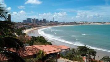 Un paisaje urbano costero con playa, edificios y palmeras.