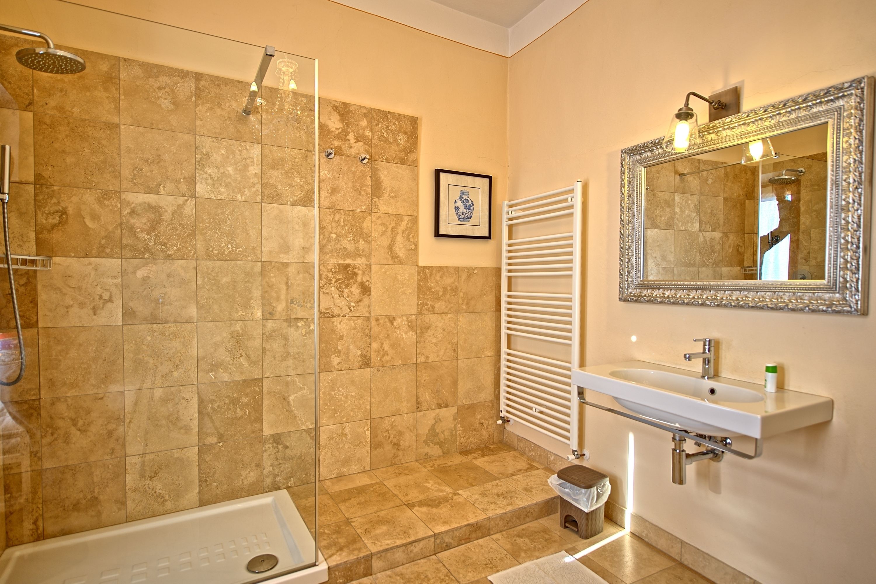Un baño con ducha, bañera, lavabo y espejo.